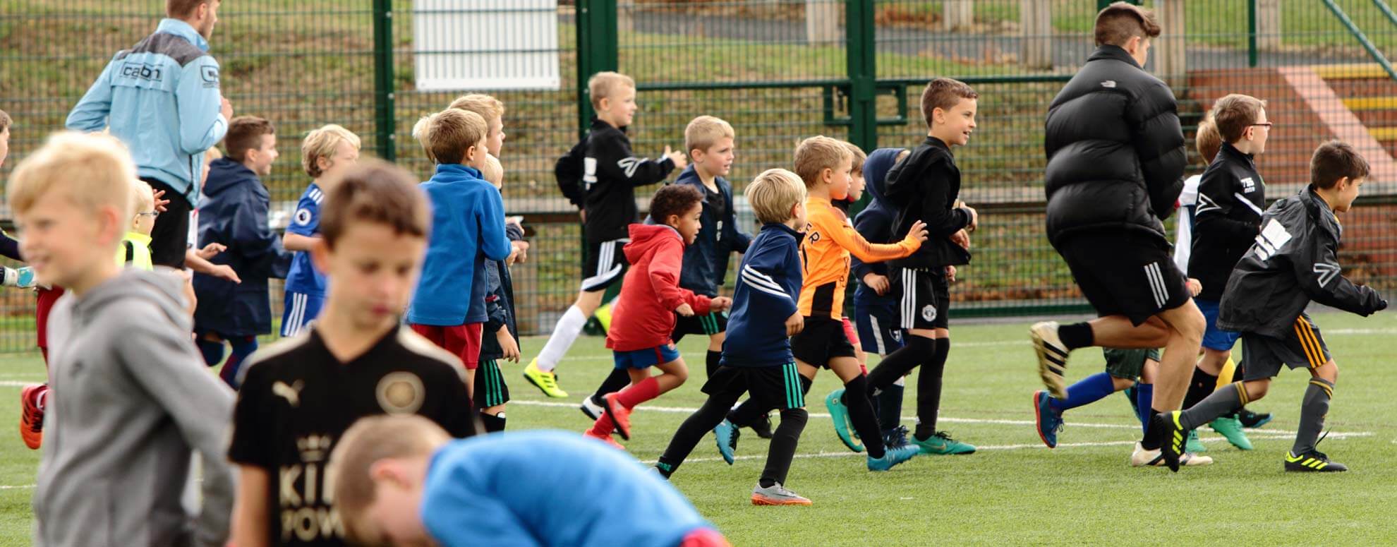 fiesta sports coaching football club group of children running