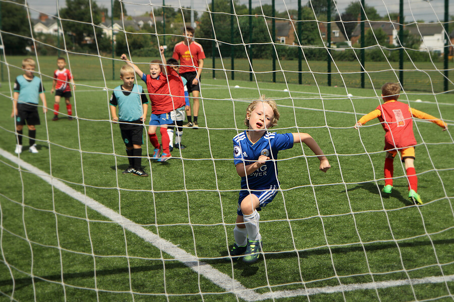 Children playing football near a goal