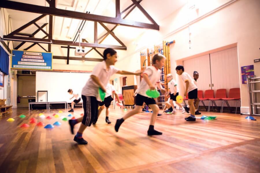 fiesta sports coaching school children playing in school hall