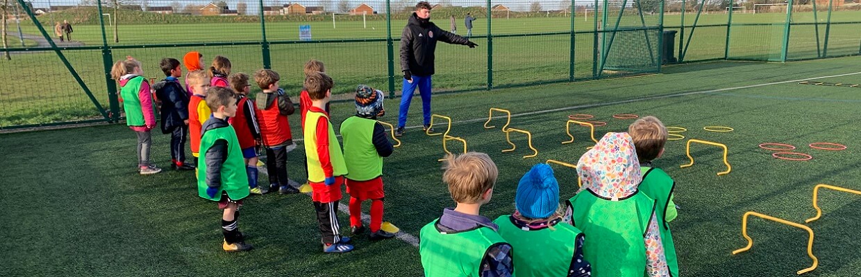 Fiesta sports coaching children at a football session