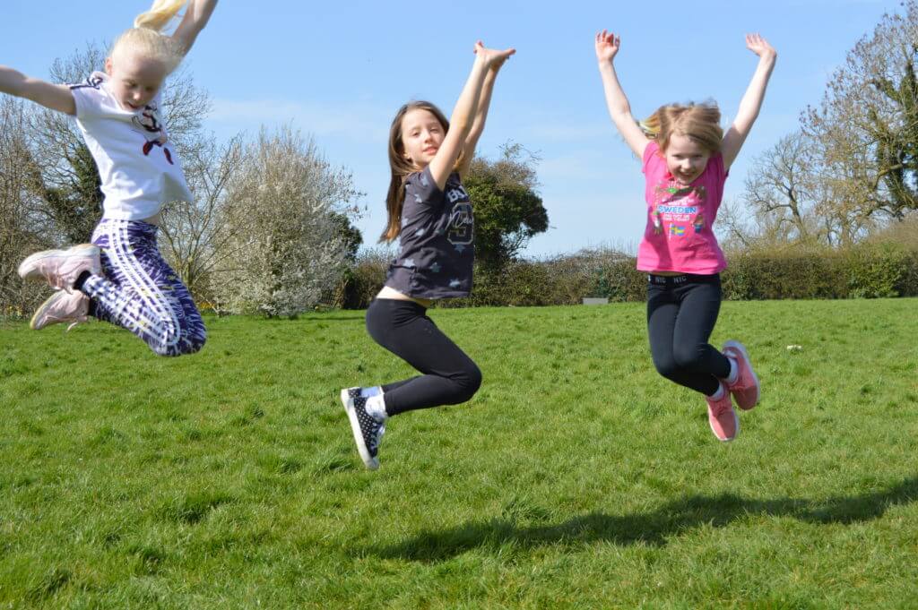 Children jumping on a field