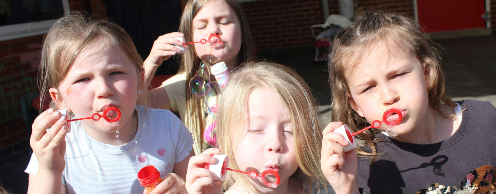 Close up of children blowing bubbles at after school club
