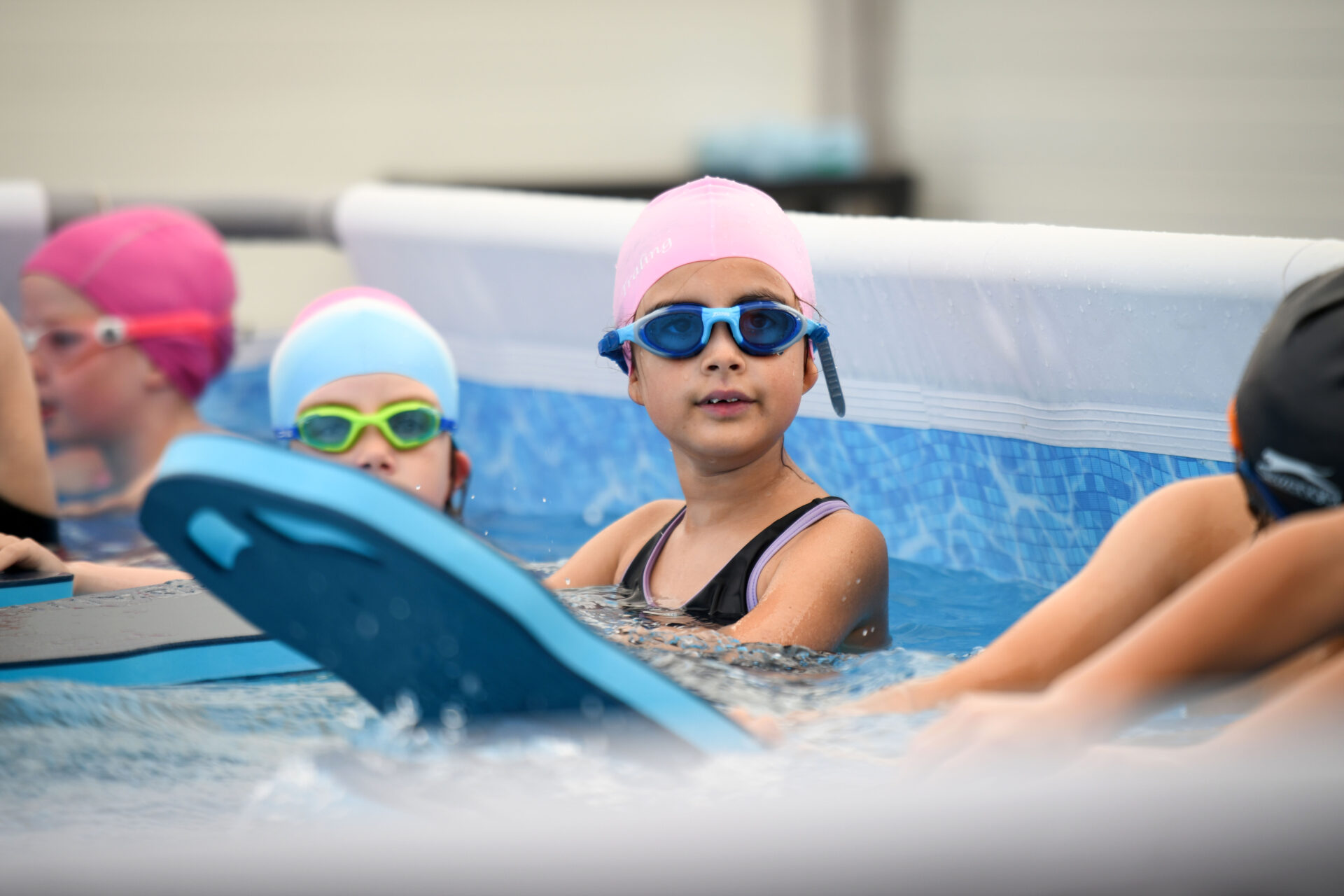 children in pop up pool with floats