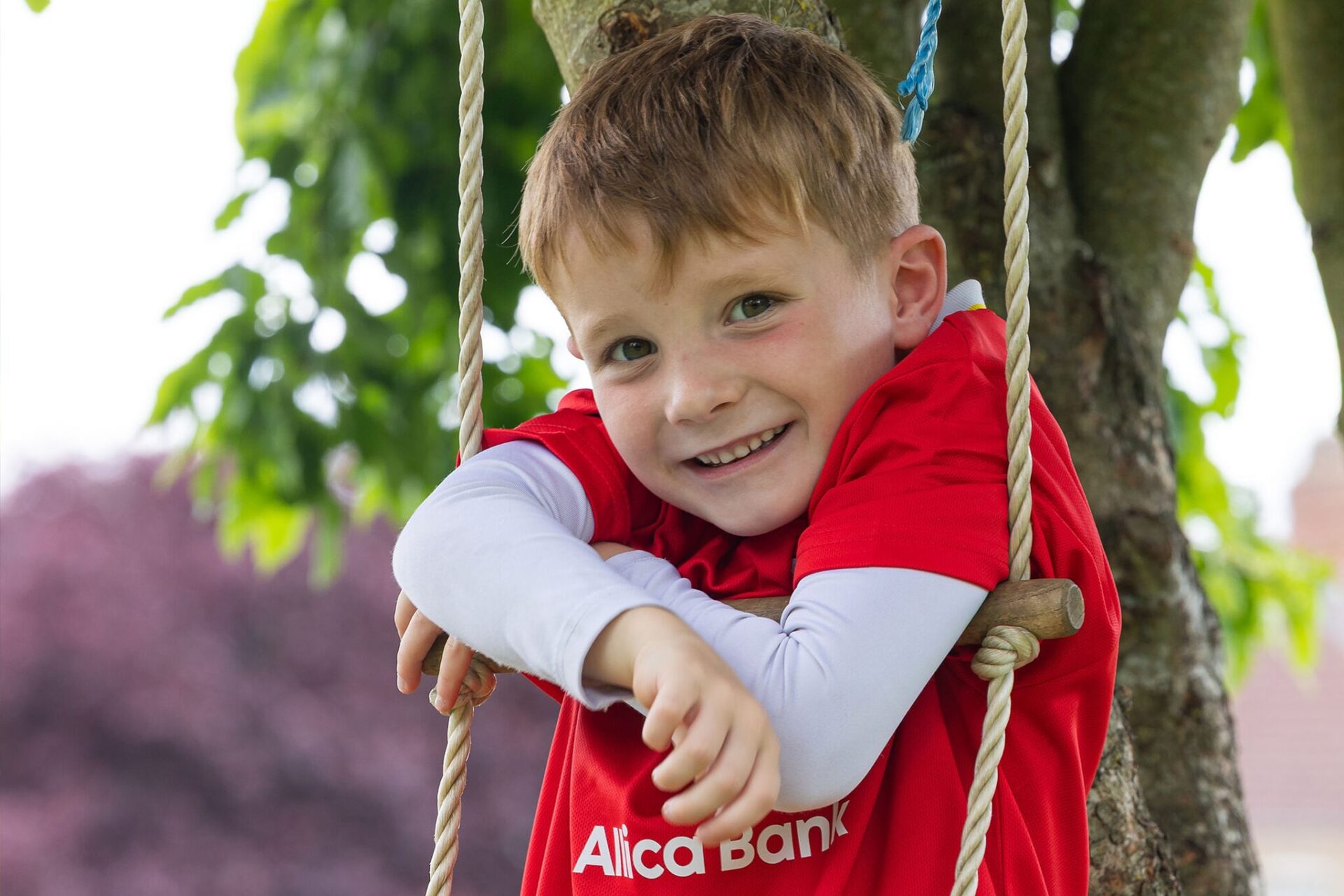 Kid on rope ladder in tree - Wraparound Care In Northamptonshire